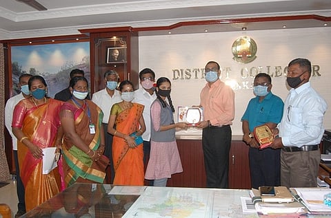 சிறப்பிடம் பெற்ற மாணவிக்கு பரிசு வழங்குகிறாா் ஆட்சியா் கீ.சு.சமீரன்.