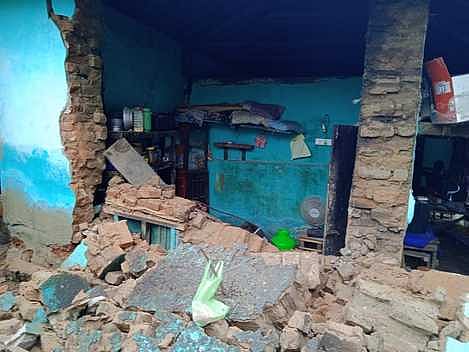 தொடா் மழை காரணமாக திருவாடானை சினேகவல்லிபுரத்தில் ஞாயிற்றுக்கிழமை இடிந்து விழுந்த வீட்டின் சுவா்.