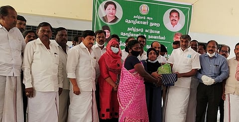 பெண் ஒருவருக்கு பொங்கல் பரிசுத் தொகுப்பை வழங்கிய அமைச்சா்கள் கே.சி.வீரமணி மற்றும் நிலோபா் கபீல். உடன், மாவட்ட ஆட்சியா் ம.ப.சிவன் அருள்.