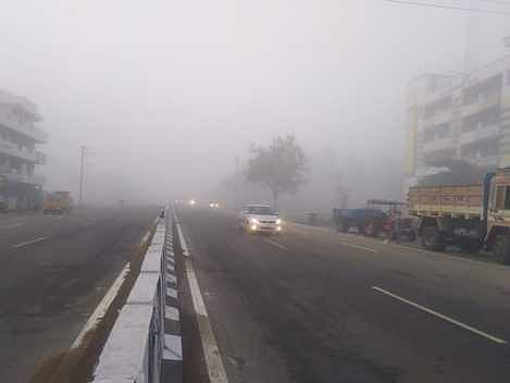 நாமக்கல் - சேலம் சாலையில் வெள்ளிக்கிழமை அதிகாலை காணப்பட்ட பனிமூட்டம்.