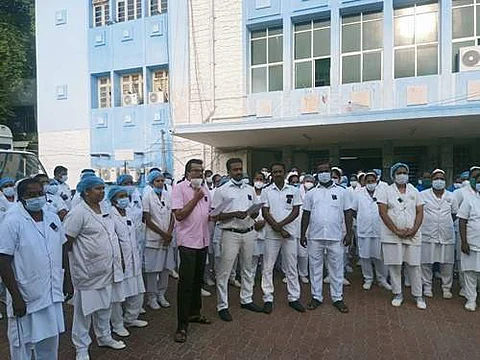 திருநெல்வேலி அரசு மருத்துவக் கல்லூரி மருத்துவமனை வளாகத்தில் வெள்ளிக்கிழமை போராட்டத்தில் ஈடுபட்ட செவிலியர்கள்.