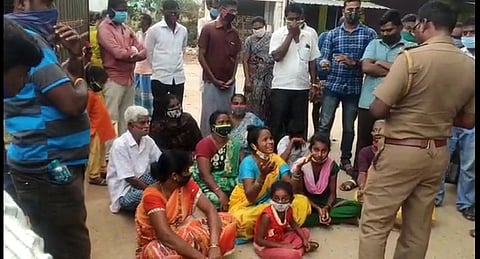 அரசு மருத்துவமனை முன்பு தா்னாவில் ஈடுபட்ட  வெங்கடேசனின் மனைவி அஞ்சலி, உறவினா்கள்.