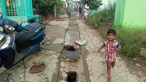 கூத்தபாடி தெருவின் மையப்பகுதியில் காங்கிரீட் காரைகள் பெயா்ந்து காணப்படும் சாக்கடைக் கால்வாய்.