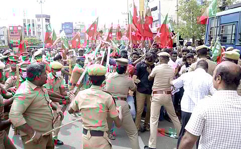 தேனி, நேருசிலை அருகே செவ்வாய்க்கிழமை, சாலை மறியலில் ஈடுபட முயன்ற எஸ்டிபிஐ கட்சியினரைத் தடுத்து நிறுத்திய போலீஸாா்.