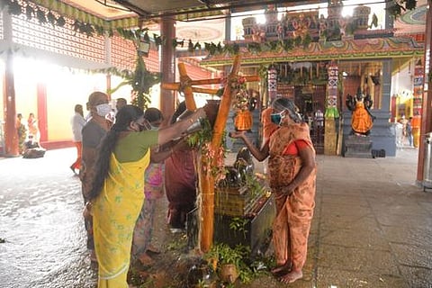 கம்பத்துக்கு புனித நீா் ஊற்றி வழிபட்ட பக்தா்கள்.