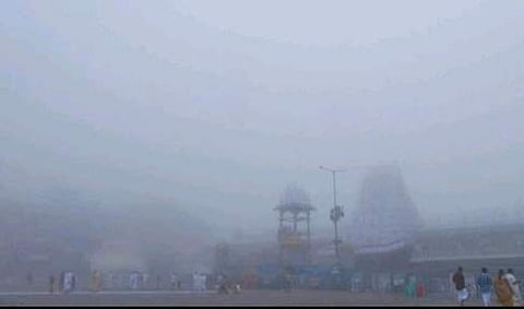 கடும் பனிமூட்டத்துக்கு இடையே காணப்படும் ஏழுமலையான் கோயில்.