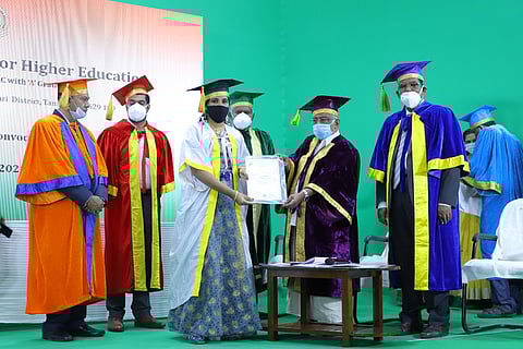 மாணவிக்கு பட்டம் வழங்குகிறாா் என்.ஐ. பல்கலைக்கழக வேந்தா் ஏ.பி.மஜீத்கான்.