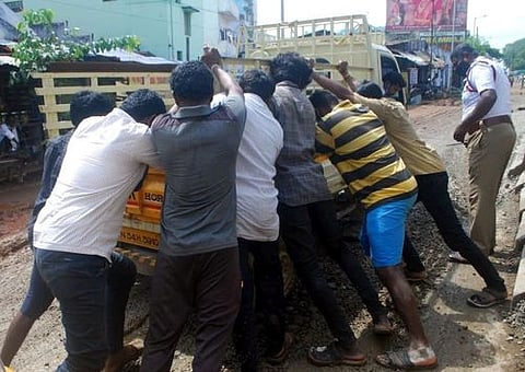 குழிக்குள் சிக்கிய வாகனத்தை மீட்ட பொதுமக்கள்.