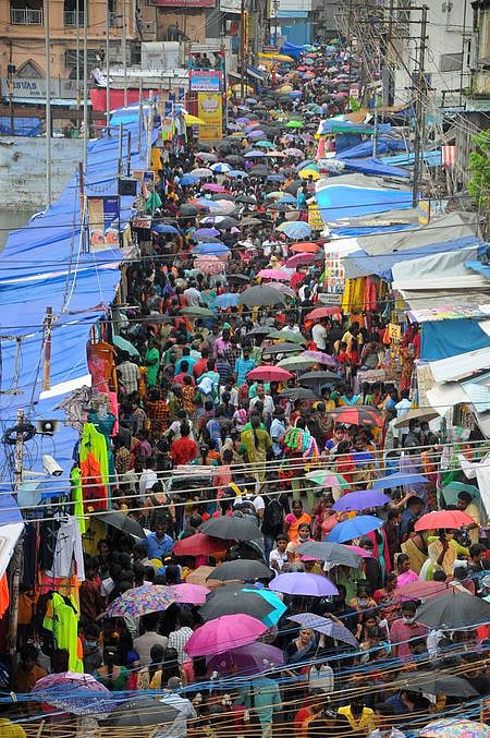 என்எஸ்பி சாலையில் பொருள்கள் வாங்க குடையுடன் குவிந்த பொதுமக்கள்.