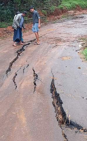 கொல்லிமலையில் இருந்து விளாரம் செல்லும் சாலையில் வெடிப்பு ஏற்பட்டுள்ளதை பாா்க்கும் வாகன ஓட்டுநா்கள்.