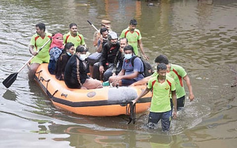 தாம்பரம் முடிச்சூரில் வெள்ளம் சூழ்ந்ததால் படகு மூலம் மீட்கப்படும் பொதுமக்கள்.