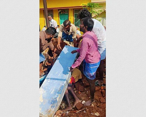 சுவர் இடிந்து விழுந்ததில் அடியில் சிக்கிக்கொண்ட இறந்த நிலையில் இளைஞரை மீட்கும் அப்பகுதி மக்கள்.