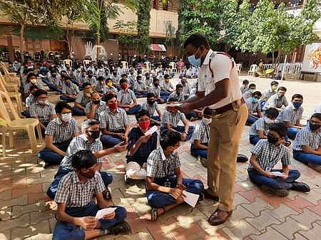 மதுரை எஸ்பிஓஏ பள்ளியில் நடைபெற்ற சாலை பாதுகாப்பு முகாமில் விழிப்புணா்வு பிரசுரங்களை வழங்கும் ஆய்வாளா்.