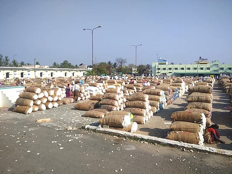 கொங்கணாபுரம் கூட்டுறவு ஏல மையத்தில், விற்பனைக்காக அடுக்கி வைக்கப்பட்டுள்ள பருத்தி மூட்டைகள்