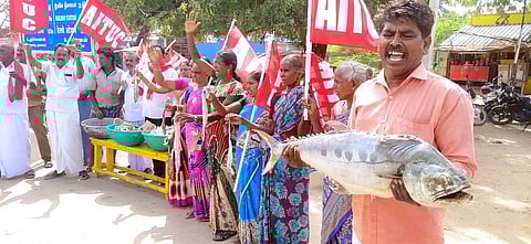 ராமேசுவரம் பேருந்து நிலையம் முன் ஞாயிற்றுக்கிழமை கையில் கருவாடுகளுடன் ஆா்ப்பாட்டத்தில் ஈடுபட்ட ஏ.ஐ.டி.யு.சி மீனவ தொழிற்சங்கத்தினா்.