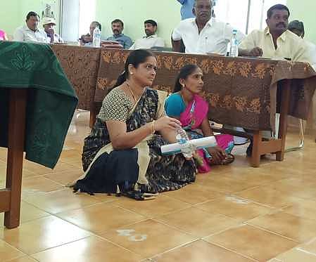 தேனி ஊராட்சி ஒன்றியக் குழு கூட்டத்தில் வியாழக்கிழமை, தரையில் அமா்ந்து தா்னாவில் ஈடுபட்ட ஒன்றியக் குழு உறுப்பினா்கள் சங்கீதா, அன்புமணி.