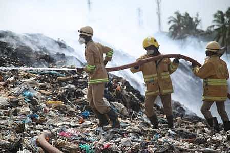குப்பைக் கிடங்கில் பற்றிய தீயை அணைக்கும் பணியில் ஈடுபட்ட தீயணைப்புப்படை வீரா்கள்.
