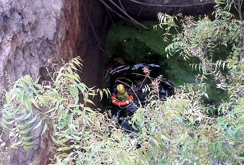 காங்கயம் அருகே, கிணற்றில் தவறி விழுந்து இறந்த மூதாட்டியின் சடலத்தை, கிணற்றில் இறங்கி மீட்கும் தீயணைப்புப் படை வீரர். 