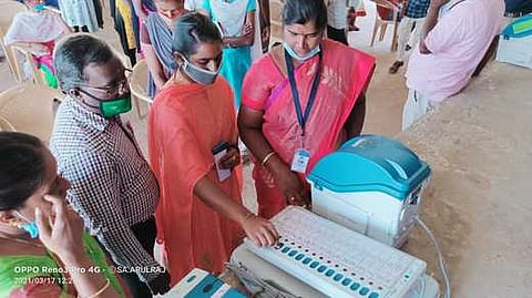 மின்னணு வாக்குப் பதிவு இயந்திரத்தில் எவ்வாறு வாக்களிப்பது குறித்து செய்லமுறை விளக்கம் அளிக்கும் தோ்தல் பிரிவு அதிகாரி.