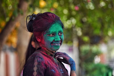 பாரம்பரிய இசை வாத்தியங்களை இசைத்து, வண்ண பொடிகளை தூவி மகிழ்ச்சியை வெளிப்படுத்திய கல்லூரி மாணவி.