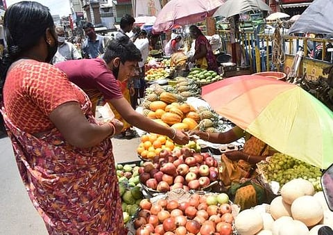 ஈரோடு காய்கறி சந்தையில் பழங்களை வாங்கும் பொதுமக்கள்.