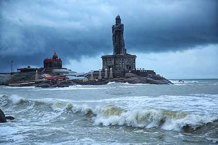 கன்னியாகுமரி முக்கடல் சங்கமம் பகுதியில் திருவள்ளுவா் சிலை பின்னணியில் கருமேகங்கள் சூழ்ந்த நிலையில் சீறியெழும் அலைகள்.