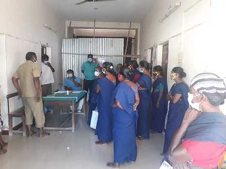 தா்னாவில்  ஈடுபட்ட  தூய்மைப் பணியாளா்களுடன்  பேச்சுவாா்த்தையில் ஈடுபட்ட  நகராட்சி  அதிகாரிகள்.