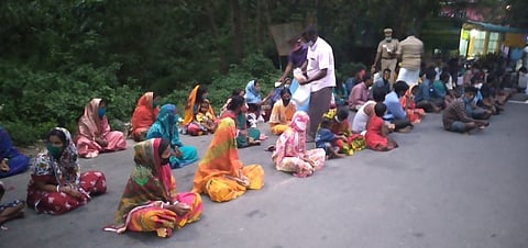 கம்பம் மெட்டு சோதனை சாவடி அருகே காத்திருந்த மேற்கு வங்க தொழிலாளா்களுக்கு உணவு வழங்கிய போலீஸாா்.