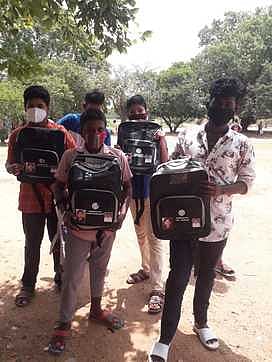 முன்னாள் முதல்வா்களின் உருவப் படங்கள் பொறித்த புத்தகப் பைகளுடன் விருத்தாசலம் அரசு ஆண்கள் மேல்நிலைப் பள்ளி மாணவா்கள்.