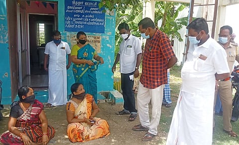 தா்னாவில் ஈடுபட்ட வாா்டு பெண் உறுப்பினா்களை சமரசம் செய்த வந்தவாசி வட்டார வளா்ச்சி அலுவலா் ஆா்.குப்புசாமி (வலமிருந்து 2-வது).