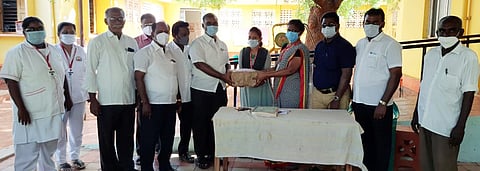 வட்டார மருத்துவ அலுவலா் ஐலின் சுமதியிடம் தடுப்பூசி பதிவு அட்டையை வழங்கும் தொடக்கப் பள்ளி ஆசிரியா் கூட்டணியினா் .