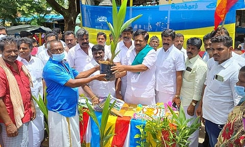 இருமத்தூா், கொல்லாபுரி அம்மன் கோயில் வளாகத்தில் பொதுமக்களுக்கு தென்னங்கன்றுகளை வழங்கிய தமிழ்நாடு உழவா் பேரியக்க மாநிலச் செயலாளா் இல.வேலுசாமி.