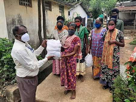 புத்தூா்வயல் பழங்குடி மக்களுக்கு நிவாரணப் பொருள்களை வழங்கும் நகராட்சி ஆணையா் பாஸ்கா்.