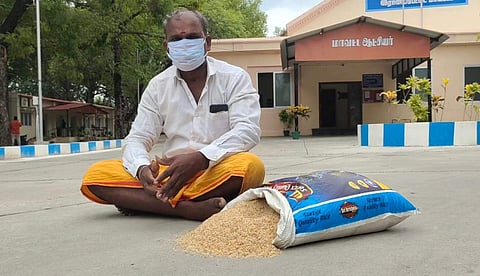 ஆட்சியர் வளாகத்தின் முன்பு தரமற்ற அரிசியை தரையில் கொட்டி தர்னாவில் ஈடுபட்ட சரவணன்.