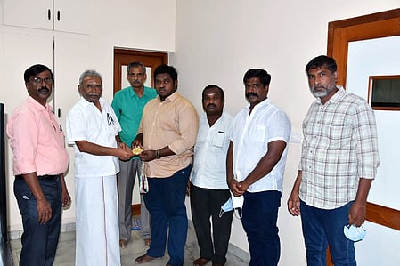 மாணவா் ருத்ரமாயனுக்கு பரிசு வழங்கி பாராட்டுகிறாா் கல்லூரிச் செயலா் கே.ஆா்.அருணாச்சலம்.