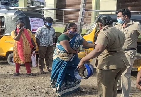 திண்டுக்கல் மாவட்ட ஆட்சியரின் முகாம் அலுவலகம் அருகே செவ்வாய்க்கிழமை தீக்குளிக்க முயன்ற நாகராணியை மீட்ட போலீஸாா்.