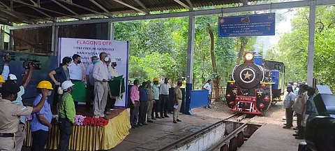 பொது மேலாளர் திருச்சி பொன்மலையில் வடிவமைக்கப்பட்ட நீராவி இன்ஜினை கொடியசைத்து தொடங்கி வைக்கும் பொது மேலாளர் ஜான் தாமஸ்.