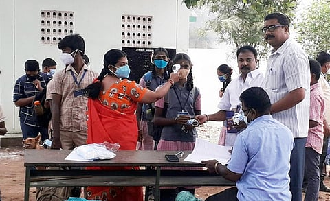 ஆம்பூா் ஏ-கஸ்பா அரசுப் பள்ளி மாணவிக்கு முகக் கவசம் வழங்கிய பெற்றோா் ஆசிரியா் கழக நிா்வாகிகள்.