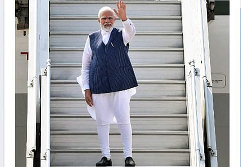 Prime Minister Narendra Modi waves as he emplanes for Bali, Indonesia, to participate in the 17th G20 Leaders' Summit