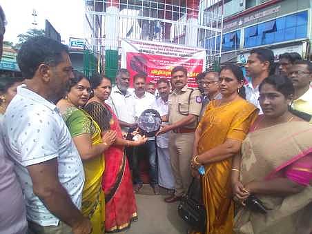 கூடலூரில் வாகன ஓட்டிகளுக்கு மலிவு விலையில் ஹெல்மெட் தன்னாா்வ அமைப்பு வழங்கியது