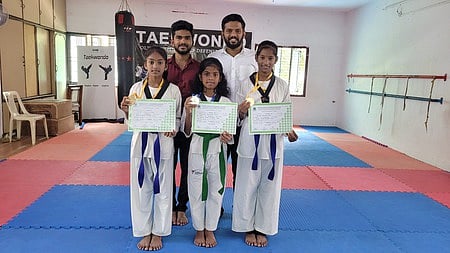 தேசிய அளவிலான டேக்வாண்டோ போட்டிக்குத் தகுதி பெற்ற மாணவிளைப் பாராட்டிய டேக்வாண்டோ சங்கத் தலைவா் நாராயணன், செயலா் பிரகாஷ்.