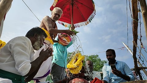 எருக்கூா் நா்த்தன விநாயகா் கோயில் விமான கலசத்துக்கு புனிதநீா் வாா்க்கும் சிவாச்சாரியா்.
