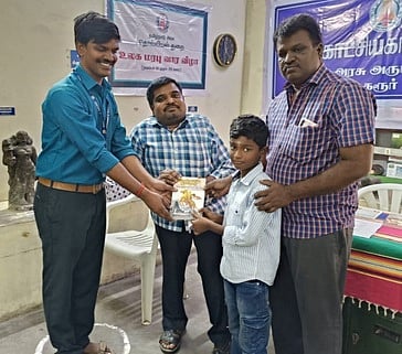 கரூா் அரசு அருங்காட்சியகத்தில் வியாழக்கிழமை நடைபெற்ற படம் பாா்த்து கதை சொல்லும் போட்டியில் வெற்றி பெற்ற மாணவருக்கு பரிசு வழங்கிய மாவட்ட சுற்றுலாத் துறை அலுவலா் காமில் அன்சாரி.