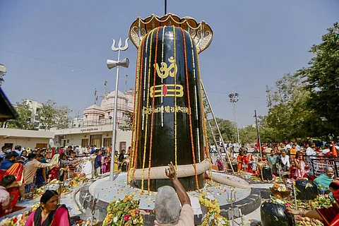 அகமதாபாத்தில் 'மகா சிவராத்திரி' திருவிழாவையொட்டி, மலர்களால் அலங்கரிக்கப்பட்ட சிவலிங்கத்தின் மீது பாலை ஊற்றி வழிப்படும் பக்தர்கள்.