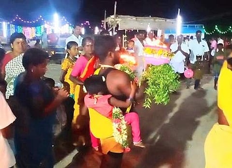 கேட்ட வரம் தரும் முத்துமாரியம்மன் கோயிலில் தனது குழந்தையை இடுப்பில் கட்டிக் கொண்டு அக்கினிச் சட்டி எடுத்து நேர்த்திக்கடன் செலுத்திய பக்தர்.