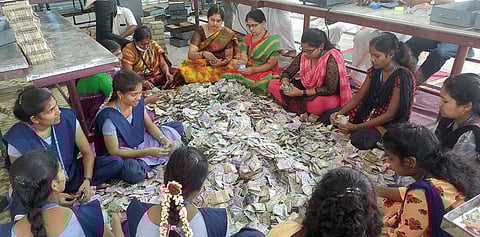 பழனி மலைக்கோயிலில் உண்டியல் காணிக்கையாக வரப்பெற்ற ரூபாய் நோட்டுகளை தரம்பிரிக்கும் பணியில் கல்லூரி அலுவலா்கள் மற்றும் மாணவிகள்.