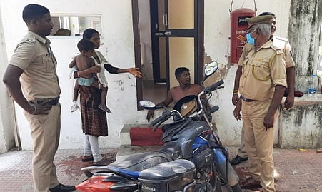 தீக்குளிக்க முயன்றவரிடம் விசாரணை நடத்தும் போலீஸாா்.