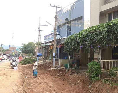 கூடலூரில் அகற்றப்படாத மின் கம்பங்கள் வழியாக நடைபெறும் நான்கு வழிச்சாலை அமைக்கும் பணிகள்.