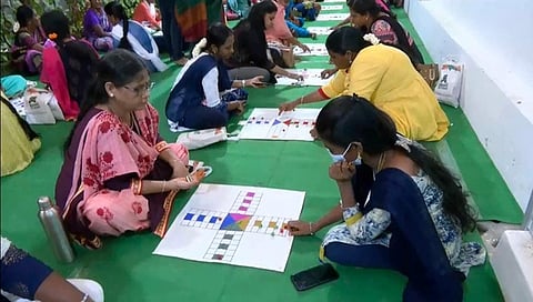 தாயம் விளையாடும் போட்டியில் பங்கேற்ற பெண்கள்.