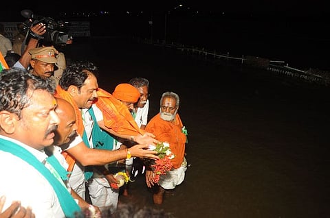 பாஜக விவசாய அணித் தலைவா் ஜி.கே.நாகராஜ் தலைமையில் காவிரித் தாய்க்கு பூக்களைத் தூவி ஆராதனை செய்யும் கட்சியினா்.